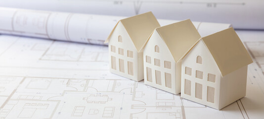 Construction concept. Residential building drawings and architectural house models on an office desk