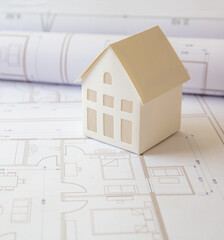 Construction concept. Residential building drawings and architectural house model on an office desk