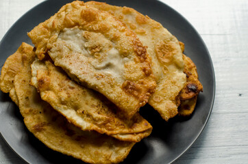 Fried flatbread with meat filling. Known in Asia as chebureks.