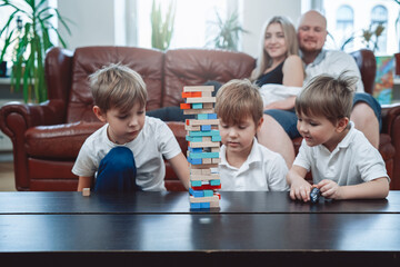 Leisure and relaxed lifestyle of caucasian family. Little brothers have fun and play board game competing at home.