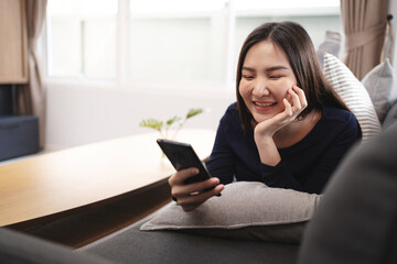 asian woman using mobile phone  at home Communication and coziness concept.