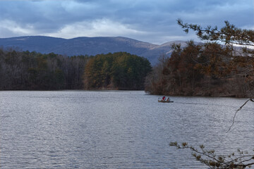 Fototapeta premium Father & son fishing in mid-winter on scenic lake