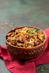 Spicy bulgur with mushrooms, onions, dill, and cumin in a bowl close-up. Bulgur stewed with mushrooms. Arabic cuisine, vegan and vegetarian food. Copy space for text