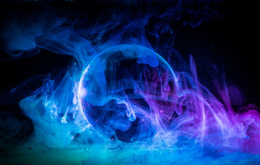 Swirling clouds of colored light around a sphere on a dark background