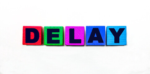 The word DELAY is written on colorful cubes on a light background