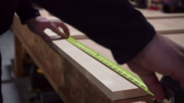 Carpenter Measuring Wood Frame With A Tape Measure. close up