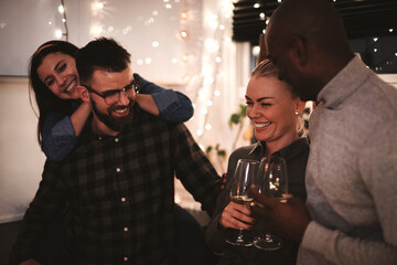 Two diverse couples laughing over wine at a party