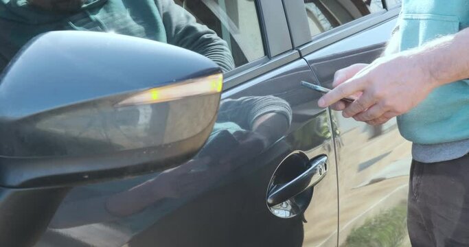 Man unlocks car door with phone app. Car sharing, transport.