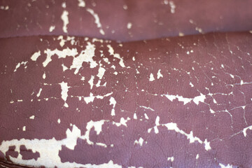 The background of the worn leather upholstery of the chair is close-up. The texture of the worn leather upholstery