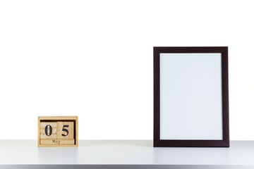 Wooden calendar 05 may with frame for photo on white table and background