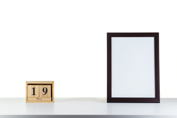 Wooden calendar 19 may with frame for photo on white table and background