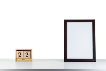 Wooden calendar 22 may with frame for photo on white table and background