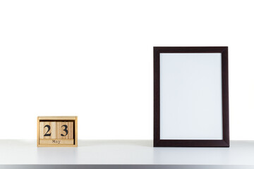 Wooden calendar 23 may with frame for photo on white table and background