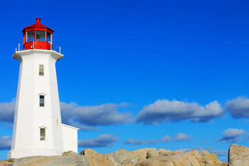Fototapeta na wymiar Light house at Peggy's Cove, Nova Scotia. Sunny, autumn day, lots of blue sky with light cloud. Lots of copy space.