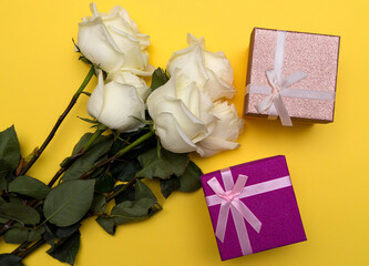 postcard. White roses on a Yellow background and boxes of gifts for her. Congratulations on March 8, Valentine's Day, Mother's Day, Birthday, Anniversary, Easter, Wedding, Teacher's Day, to women.