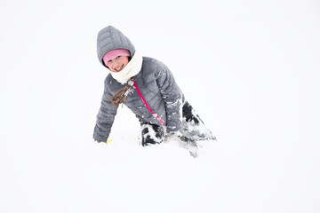 Fototapeta na wymiar Child in winter. Cheerful little girl in warm clothes in the snow.