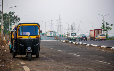 Traditional black yellow tuk tuk taxi on the street Mumbai
