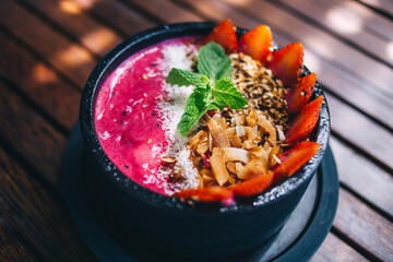 Healthy breakfast bowl. Blueberry smoothie with banana, raspberry, pitaya, blackberry, almonds, sunflower and chia seeds. Healthy food concept. Top view, close up.