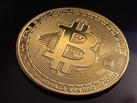 Golden bitcoin coin on dark background, bitcoin is most popular crypto currency with copy space