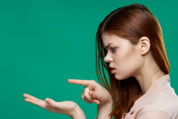 Obraz premium emotional woman looking at palms studio cropped view green background