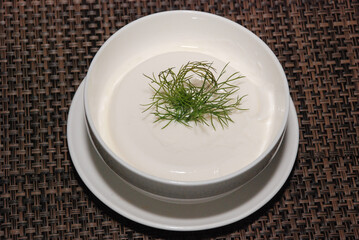 sour cream in the white bowl with green dill