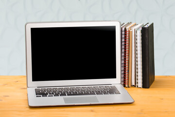 Notebook with multi-colored books on a wooden table. mocap. work from home