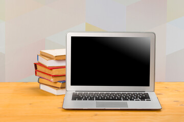 Fototapeta premium Notebook with multi-colored books on a wooden table. mocap. work from home
