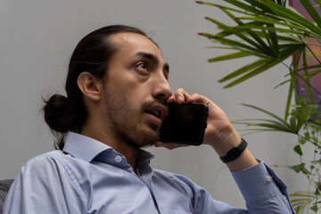 businessman talking on a cell phone while sitting on a comfortable sofa