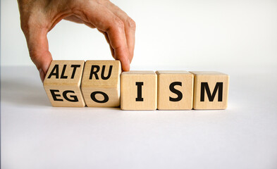 Altruism or egoism symbol. Businessman turns wooden cubes and changes the word 'egoism' to...