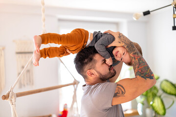 Father and baby son having fun together at home

