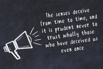 Chalk loudspeaker and wise quote on black desk © iushakovsky