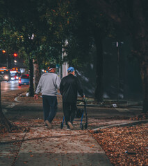 man woman elderly walking city trees lights traffic markara virus coronavirus elderly seniors walk