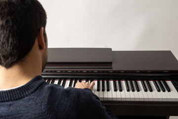 young man playing piano on the white background