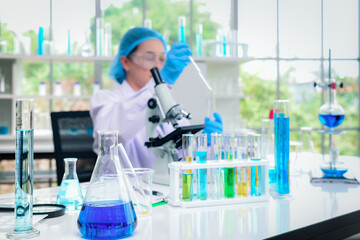 Fototapeta premium The laboratory glassware was placed in the front of Asian senior women Scientists are experimenting and examining specimens with microscopes in the lab.