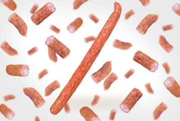 Thin Bavarian hunting sausages levitate on a white background. Falling Thin Bavarian Hunting Sausages. Meat in the air