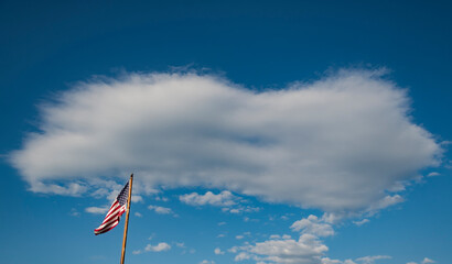 American flag on the blue and cloudy sky