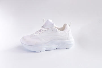 Fototapeta na wymiar one white sporty shoes on light background, side view of white sneakers