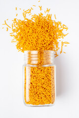 Spicy Aloo Bhujia spilled out and in a glass jar, made with Red chili, Potatoes, and Chickpeas....