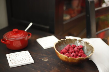 Maliny w ceramicznej miseczce na drewnianym stole © Seance_Photo_Sylwia