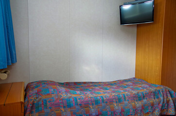 Cozy but dated cabin or stateroom on classic cruiseship or cruise ship liner with single bed, day...