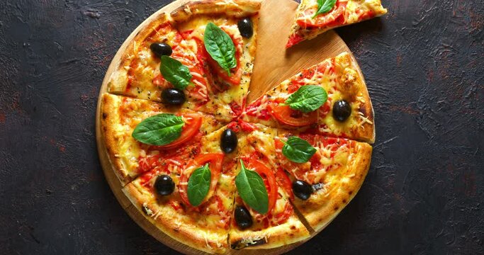 Pizza with cheese and tomatoes, cut into pieces on a wooden board, is spun, then eaten. Stop motion.
