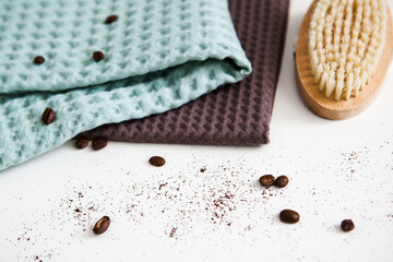spa and relaxation towels, brown and green towels on a white background with coffee beans, anti-cellulite brush
