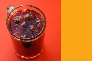 Beer mug with strawberry jam on red-yellow. Hot colors. Top view. Copy space. 