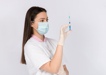 Woman holding vaccine syringe, wearing face mask and gloves, vaccine against corona virus covid 19, time of pandemic