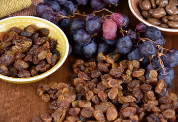 Dried raisins with a bunch of grapes stock images. Raisins sultanas still life photo images. Drying grapes and raisins in chocolate images