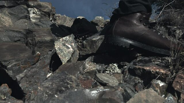 A traveler stepping down the stone path in boots