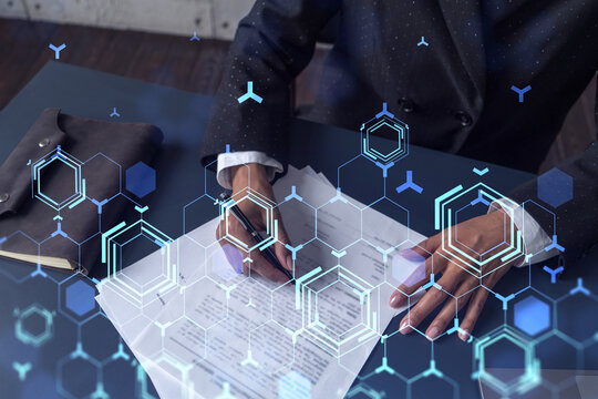 African American businesswoman is signing a contract to create a new software to present it in start up conference and gain investments to create a product. Technological graph over the desk.