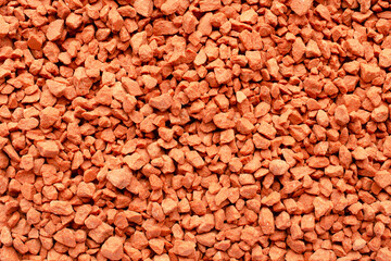 Potassium chloride is a red mineral fertilizer, top view. Red background of fertilizer potassium chloride. Texture of granular potassium chloride is red. Background mineral fertilizers, top view.