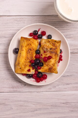 Rolled thin pancakes stuffed with cottage cheese and berries