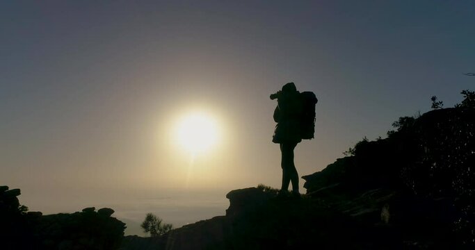 Contraluz de mujer de mediana edad fot&oacute;grafa al amanecer